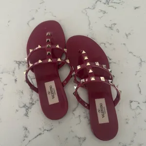 - Valentino Garavani PVC Jelly Rockstud Caged Flat Thong Sandals 35 Blossom