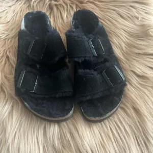 BLACK SUEDE BIRKENSTOCK SHEARLING SANDALS.