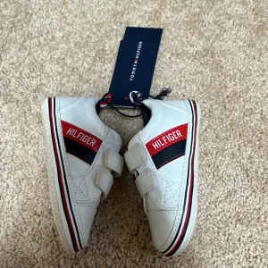 New! Tommy Hilfiger SZ 4, 9-12 months white with logo Velcro shoes.