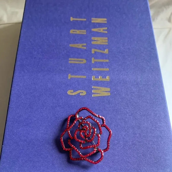 Stuart Weitzman “Ramblin Rose” heels in ruby red satin with matching brooch.